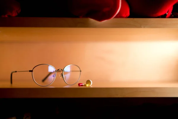 Brille und Pillen liegen im Regal, Kopierraum — Stockfoto