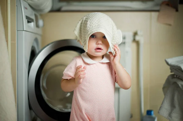 Kleines Mädchen im Badezimmer und in der Waschmaschine — Stockfoto