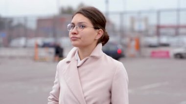 Gözlüklü genç bir kadın netlik bölgesine girer, bir telefon alır ve çalmaya başlar, etrafında bir şey ya da birini arıyor.