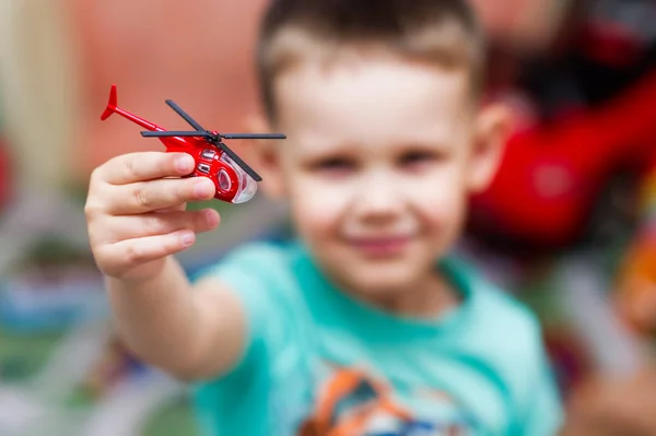 Çocuk bir oyuncak kırmızı helikopter ile oynuyor — Stok fotoğraf