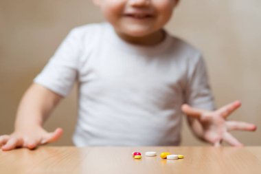 İlaçlar masanın üstünde ve gülümseyen bir bebek.