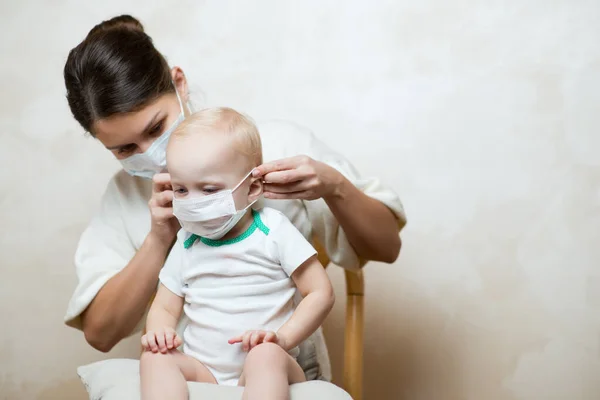 Anne küçük kızına tıbbi maske takıyor. Boşluğu kopyala — Stok fotoğraf