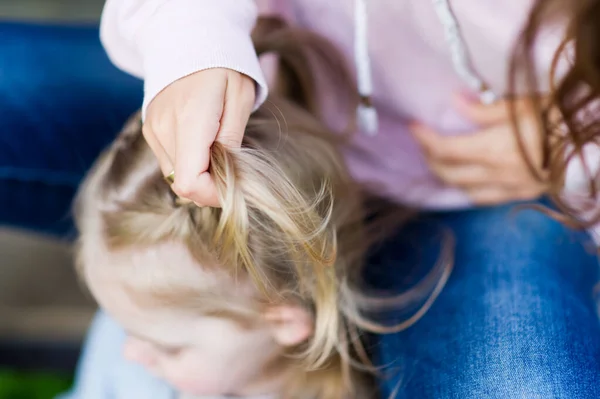 Bir kız için örgü örmek. Sarışın bir kızın saçından örgü ören bir kadının elleri — Stok fotoğraf