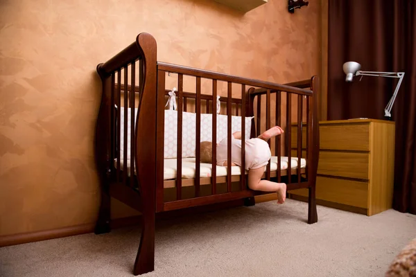 Stock image the child is trying to get into the crib. Escape from the crib