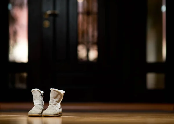 Children's boots stand lonely near the front door of the house — Stock Photo, Image