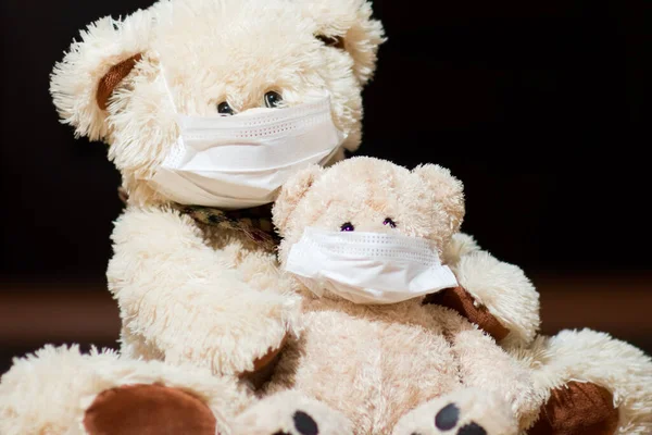 Deux ours en peluche dans des masques médicaux sont assis près de la porte, fermer — Photo