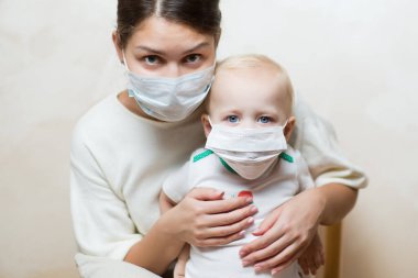 Tıbbi maskeli bir kadın ve bebek, yaklaşın.