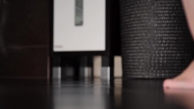 Banyoya giren, eteğini çıkaran ve duşa giren bir kadının bacaklarının alt görüntüsü.