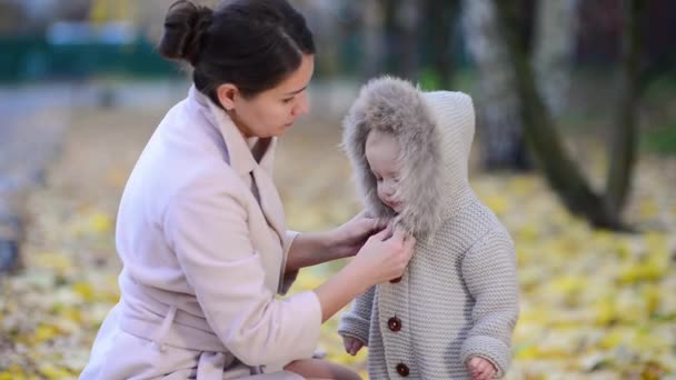 Mutter Schnallt Ihre Kleine Tochter Herbstabend Vorsichtig Auf Der Straße — Stockvideo