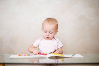 Küçük kız bir albüm için kalem seçiyor.