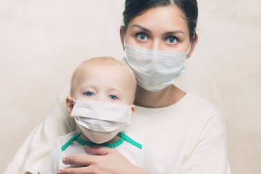 Tıbbi maskeli bir kadın ve bebek, yaklaşın.