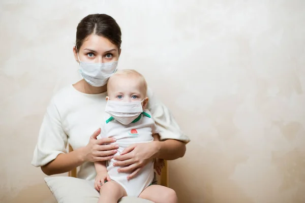 Femme et bébé dans des masques médicaux — Photo