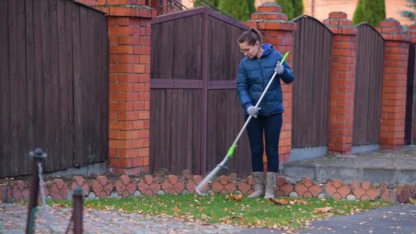 Jovem Mulher Remove Folhas Caídas Com Ancinho Gramado Frente Casa — Vídeo de Stock