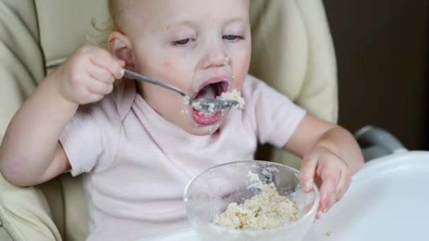 Een Klein Meisje Eet Onnauwkeurig Pap Met Een Lepel Close — Stockvideo