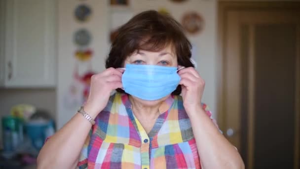 Stárnoucí Žena Nasazuje Ochrannou Lékařskou Masku Kuchyni Zblízka Pandemie Koronaviru — Stock video