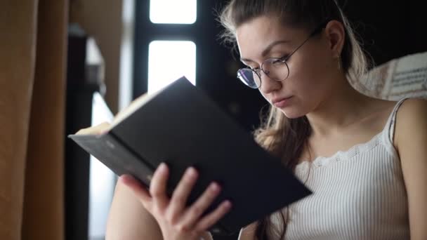 Ragazza Con Gli Occhiali Legge Libro Primo Piano — Video Stock