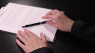Kadın sahte sözleşmeye imza atıyor, yakın plan.