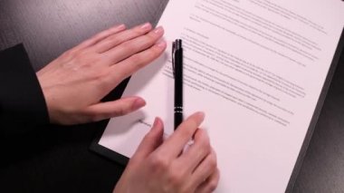İş elbisesi giymiş bir kadın tarafından imzalanan sahte sözleşme. Yakın plan.