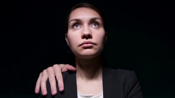 En okänd mans hand ligger på en ung kvinnas axel i en jacka. — Stockvideo