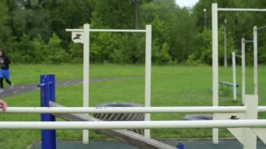 Eğitimli bir adamın yan görüntüsü. Ergen barlarda şınav çekiyor, temiz havada antrenman yapıyor.