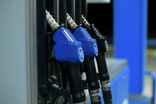 refueling pump guns hang at a gas station in the evening, close up