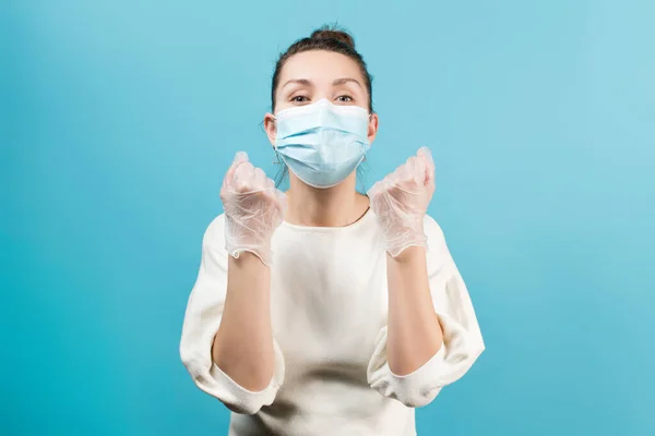 医療用マスクや医療用手袋の女は要求をミュートで拳 青い背景に隔離された — ストック写真