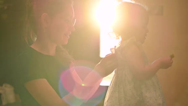 Maman et fille se prélassent et s'embrassent dans les rayons du soleil couchant — Video