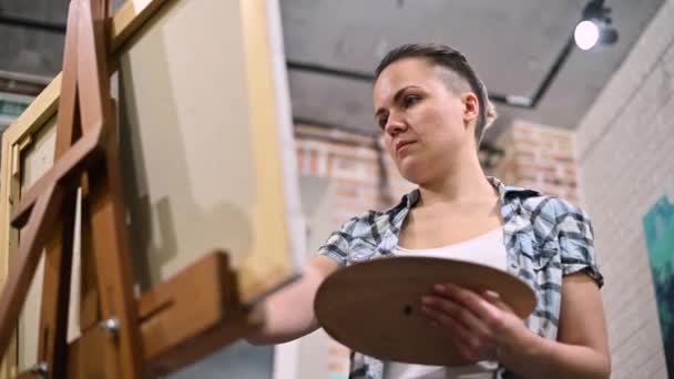 Женщина, которая рисует в студии. восторженный художник за работой — стоковое видео