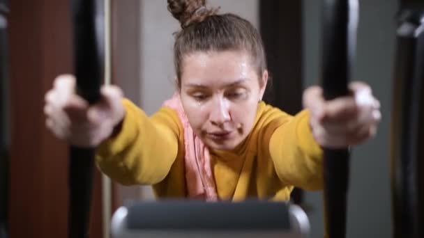 Dívka ztrácí sílu při tréninku a sklouzává dolů sportovní tréninkový stroj — Stock video