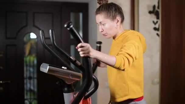 Flickan tränar, torkar svett med en handduk och klämmer en våt handduk genom — Stockvideo