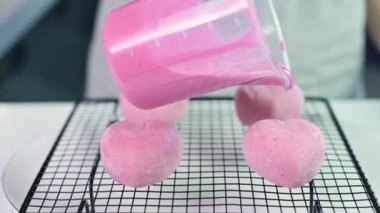 Pembe krema donmuş keklerin üzerine dökülür.