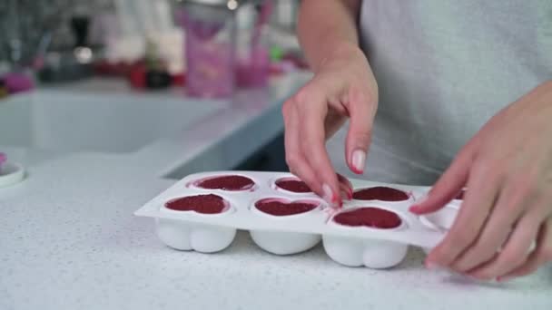 Девушка достает замороженную розовую заготовку торта из силиконовой формы — стоковое видео