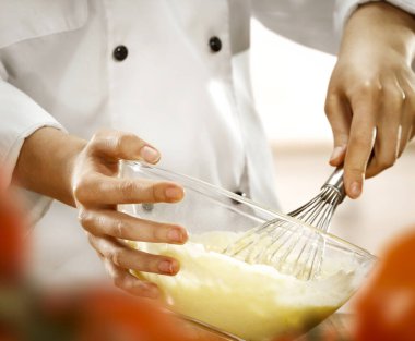 Şefin kadın elleri mutfakta yemek hazırlıyor. Pasta ve ekmek pişiriyorum. Beyaz şef üniformalı bir kadın..