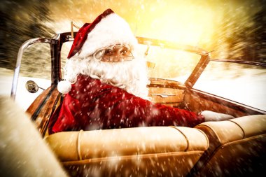 Noel Baba, güneşli bir kış gününde Noel hediyelerini teslim etmek için arabayla geliyor. Kırmızı ve altın arka planda Noel süslemesi.