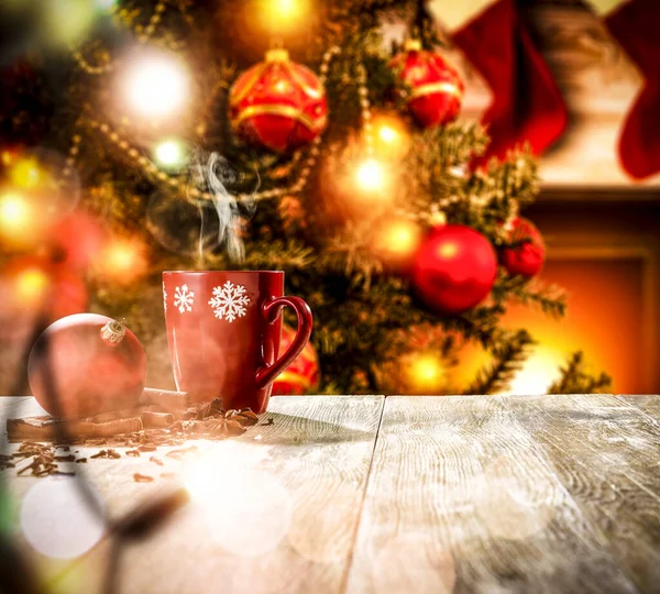広告商品のスペースのある木製のテーブル 偉大な緑のクリスマスツリーと暖炉を焼きますサンタクロースの背景の炎と赤い靴下 — ストック写真