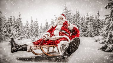 Karlı kış geçmişi olan Noel Baba. Yoğun bir kış gününde ulaşımı sunar. Kara bulanmış ladin ve köknar ağaçları.