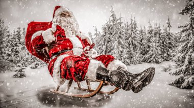 Karlı kış geçmişi olan Noel Baba. Yoğun bir kış gününde ulaşımı sunar. Kara bulanmış ladin ve köknar ağaçları.