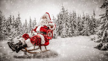 Karlı kış geçmişi olan Noel Baba. Yoğun bir kış gününde ulaşımı sunar. Kara bulanmış ladin ve köknar ağaçları.