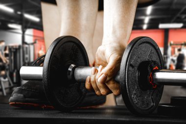 Aptal, halter ve spor salonunda egzersiz. Ürünler ve dekorasyonlar için veya bulanık spor salonu arka planına sahip metin için boşluk.