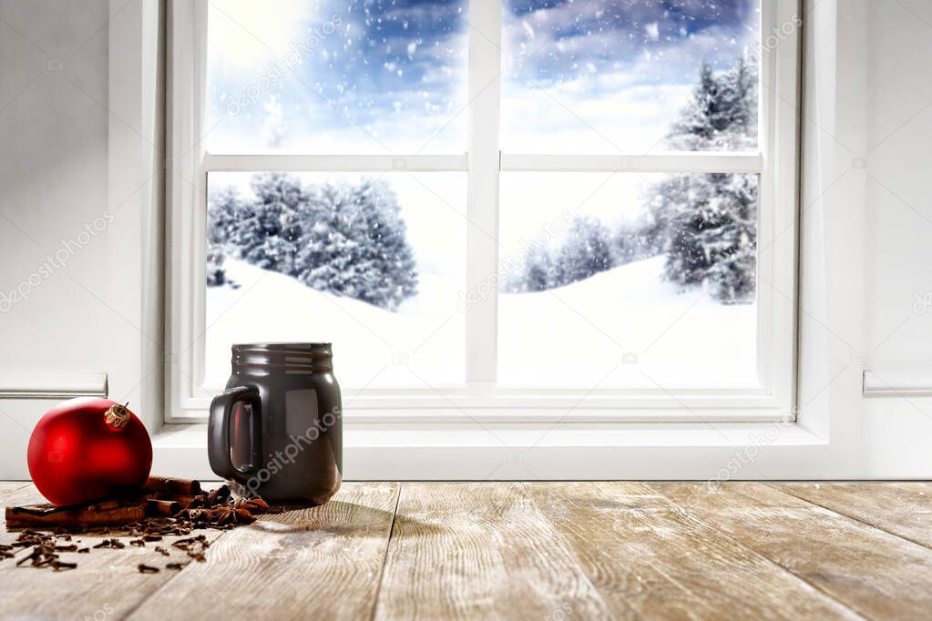 Snowy winter glimmering and shiny landscape outside the window with christmas decorations on wooden board top and space  for products and decorations.