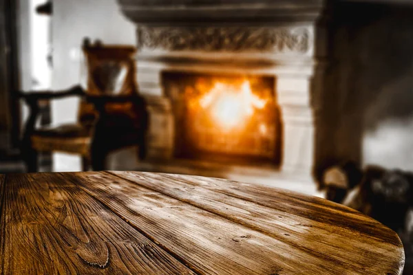 Wooden top with cosy warm home interior with fireplace background.