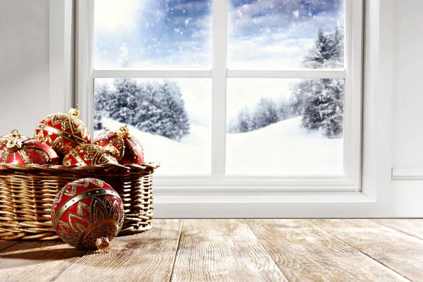 Snowy winter view outside the window with table background for products and decorations.