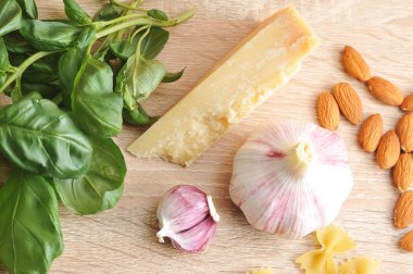 Pesto sosu yapmak için ayarlayın. Sarımsak baş ve ayrı denticles, taze fesleğen, parmesan peyniri ve badem bir demet. Açık ahşap arka plan. Yukarıdan görüntüleyin. Close. Makro çekimi.