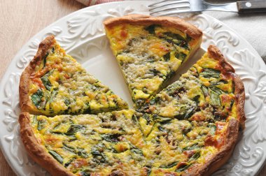 Beyaz bir tabak üzerinde ıspanak ile quiche açık pasta. Yukarıdan görüntüle.