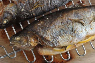 Izgarada pişmiş nehir alabalığı. Balık yüzeyinde deniz tuzu ve biberiye fark edilir. Yukarıdan görüntüleyin. Close. Makro fotoğrafçılık.
