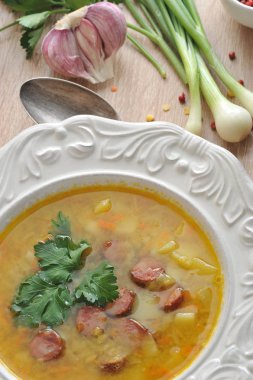 Füme etli bezelye çorbası ve taze maydanoz. Tabağın yanında bir kaşık ve bir dizi baharat var: yeşil soğan, sarımsak, biber. Yukarıdan görüntüleyin. Close. Makro fotoğrafçılık.