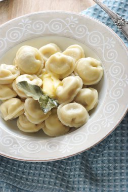 Tereyağı ve defne yaprağı ile derin bir tabakta ev yapımı köfte. Tabağın altında bir bez peçete var. Yukarıdan görüntüleyin. Close. Dikey yönlendirme. Makro fotoğrafçılık.