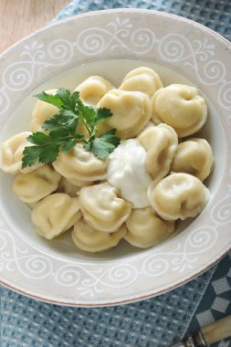 Köfte maydanoz ve ekşi krema ile derin bir tabakta ev yapımı. Tabağın altında bir bez peçete var. Yukarıdan görüntüleyin. Close. Dikey yönlendirme. Makro fotoğrafçılık.