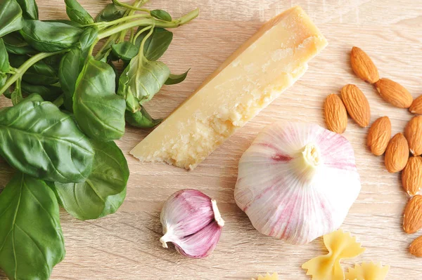 Pesto sosu yapmak için ayarlayın. Sarımsak baş ve ayrı denticles, taze fesleğen, parmesan peyniri ve badem bir demet. Açık ahşap arka plan. Yukarıdan görüntüleyin. Close. Makro çekimi.