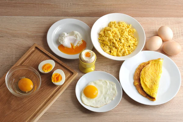 Various ways of cooking chicken eggs. Omelette, poached, soft-boiled, hard-boiled, fried, scrambled eggs. Close-up.